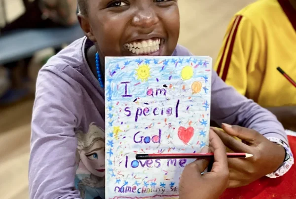 Girl smiling and holding up her I am Special Artwork