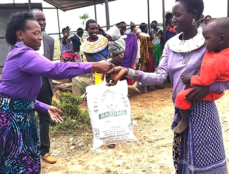 African Woman Rice and Child A large bag of Rice being give to a mother holding a child on her hip