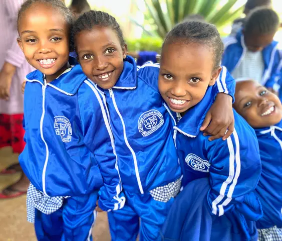3 cute African Girls in Blue track suit school uniforms.