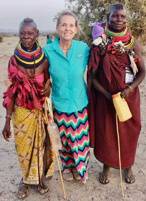 Melody with two African women adorned in tall beaded necklaces