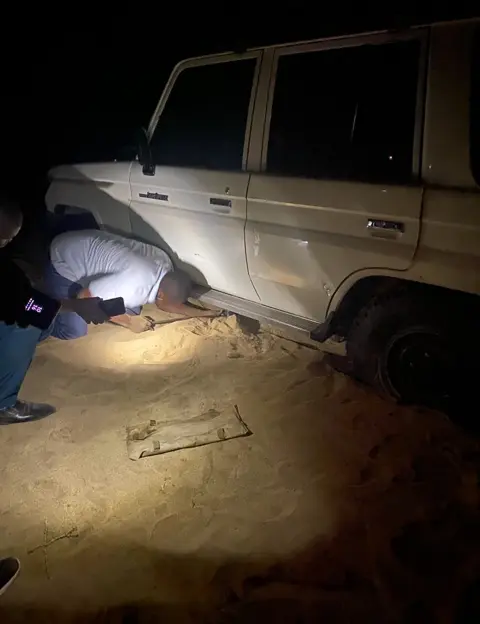 Truck Stuck in the mud while man works to find a solution