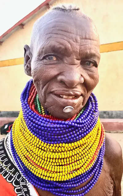 Elder African Man with lots of beaded necklaces and pierced chin