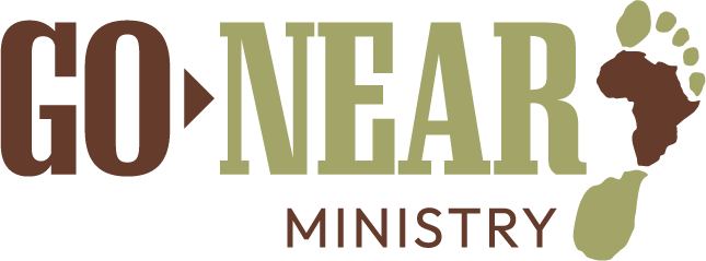 Go Near Ministry Logo which is brown and green with a small brown arrow between go and near. A foot is curved slightly around the letter R at the end of the word Near. The ball of the foot is the shape of africa.